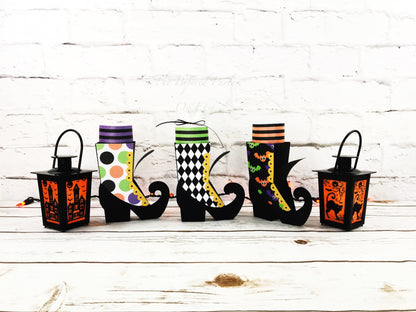 Witch boot party box. The witch boots are black but designed with different outer design. The outer designs are circles, a black and white argyle design and a bat design. The witch party boxes have striped socks that adorn the top of the boot.