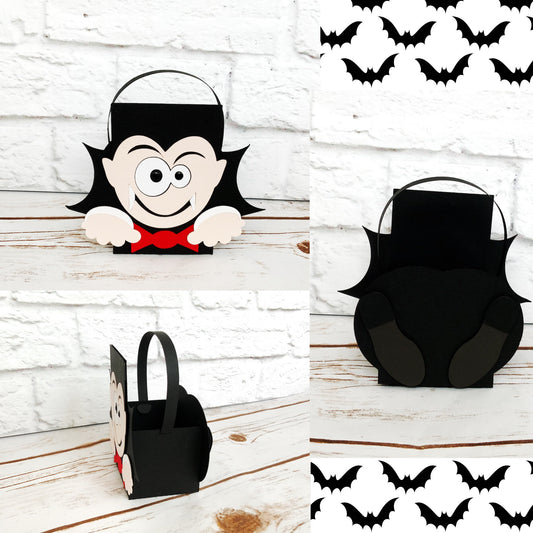 Vampire Halloween party box. The vampire box is black but has the face of a vampire wearing a red bow tie on the front with his hands at the bottom. His cute dress shoes are displayed on the back of the box.